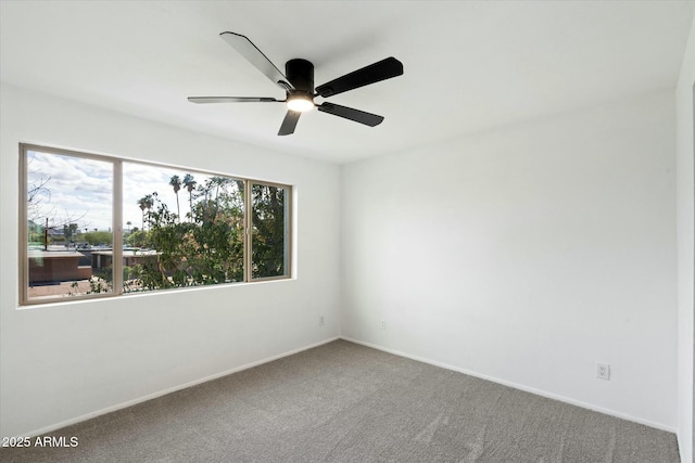 carpeted spare room with baseboards and a ceiling fan