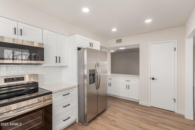 10750 W Abbott Ave, Sun City, AZ 85351 - kitchen featuring light wood finished floors, light countertops, appliances with stainless steel finishes, and white cabinets