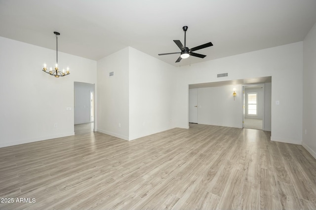 spare room with ceiling fan with notable chandelier and light hardwood / wood-style flooring