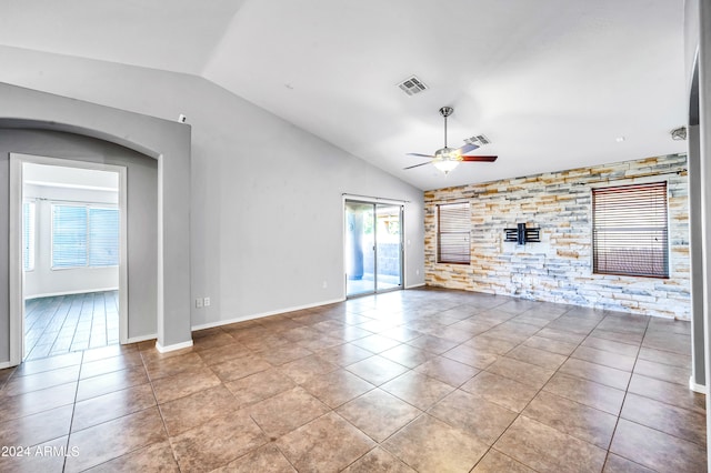 unfurnished living room with ceiling fan, a fireplace, light tile patterned flooring, and lofted ceiling