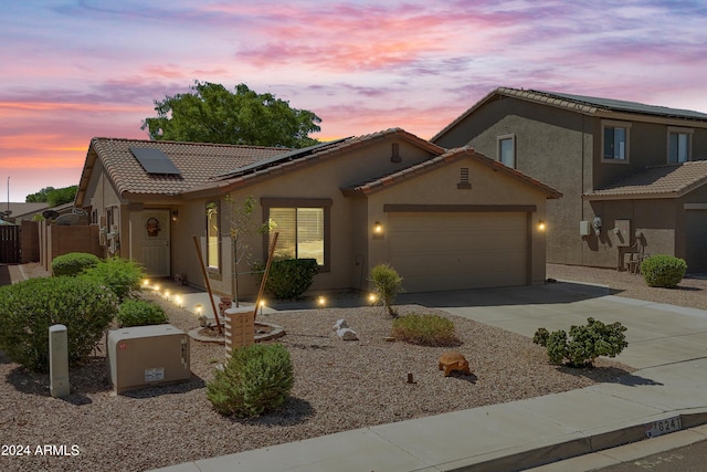 view of front of property with a garage and solar panels