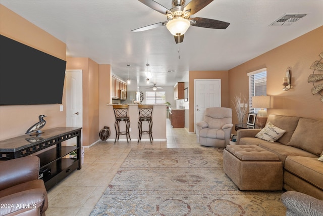 tiled living room with ceiling fan and a wealth of natural light