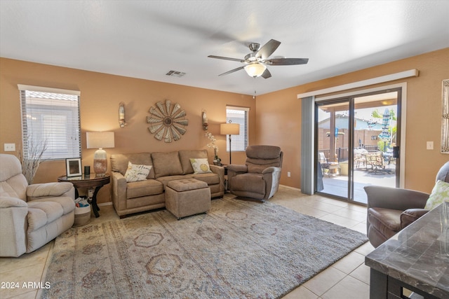 living room featuring a healthy amount of sunlight, light tile patterned floors, and ceiling fan