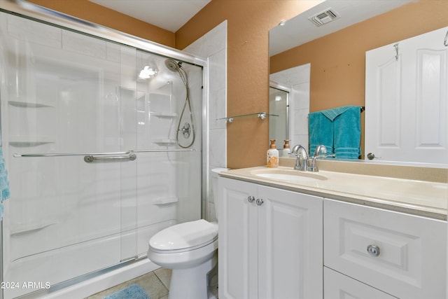 bathroom with tile patterned flooring, vanity, toilet, and an enclosed shower