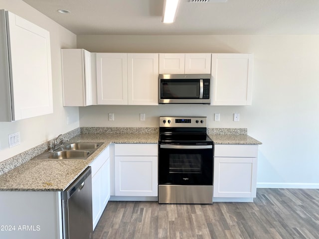 kitchen featuring white cabinets, wood-type flooring, stainless steel appliances, and sink