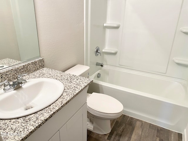 full bathroom featuring washtub / shower combination, wood-type flooring, vanity, and toilet