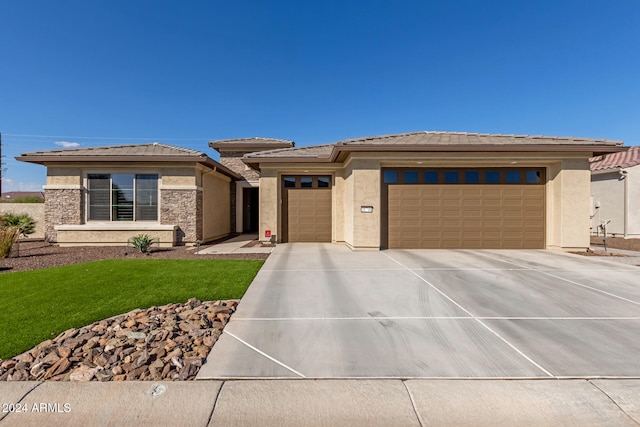 prairie-style house featuring a front lawn and a garage