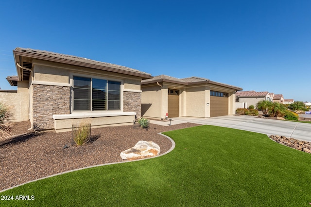 prairie-style home featuring a garage and a front yard