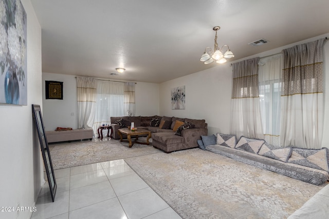 living room with plenty of natural light, tile patterned floors, and a chandelier