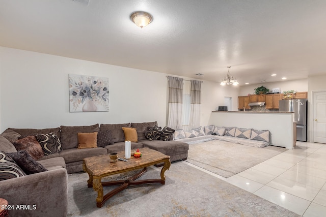 living room featuring light tile patterned flooring and an inviting chandelier