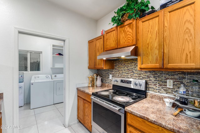 kitchen with decorative backsplash, light stone countertops, light tile patterned floors, washing machine and dryer, and stainless steel electric range oven