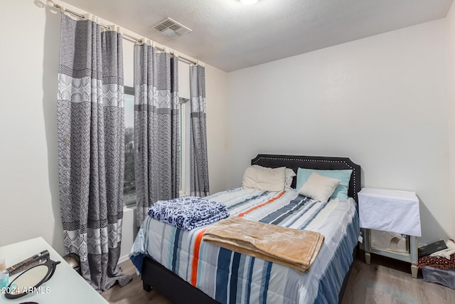 bedroom with dark wood-type flooring and a textured ceiling