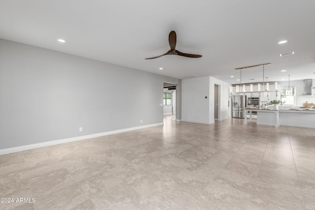 unfurnished living room featuring ceiling fan