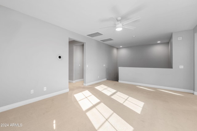 spare room featuring ceiling fan and light carpet