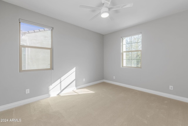 carpeted spare room featuring ceiling fan