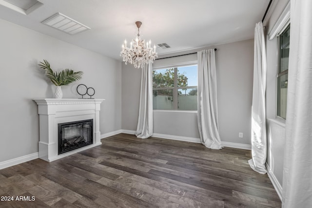 unfurnished living room with dark wood-type flooring and a chandelier