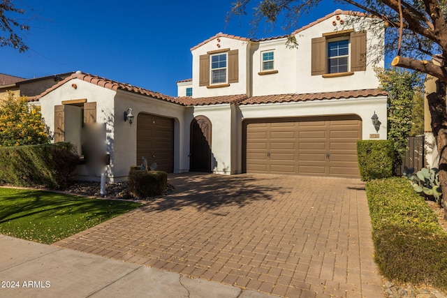 mediterranean / spanish home featuring a garage