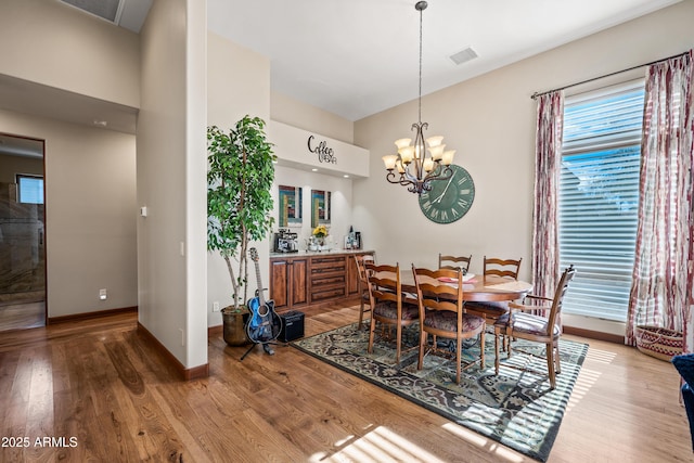 dining space featuring hardwood / wood-style floors and a notable chandelier