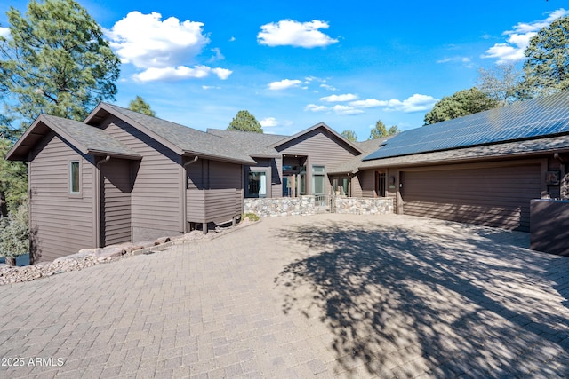 view of front of home featuring a garage and solar panels