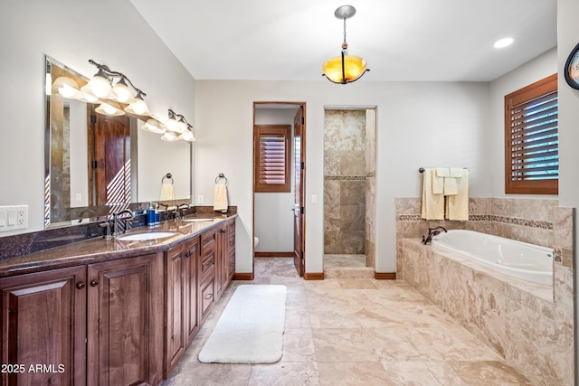 bathroom with vanity and shower with separate bathtub