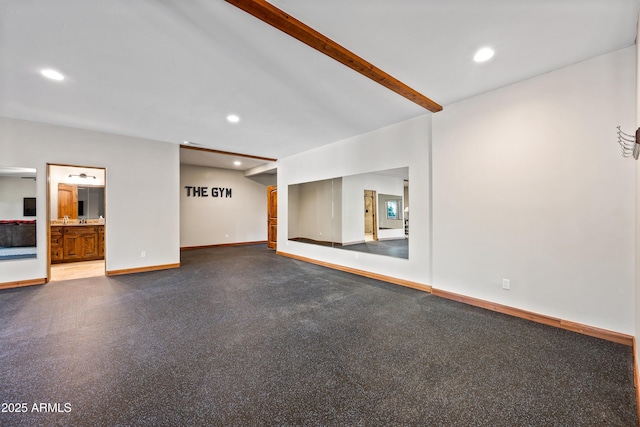 unfurnished room featuring beam ceiling