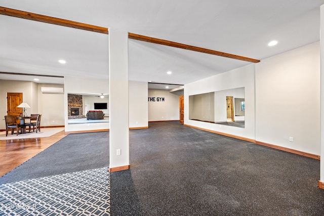 basement with a brick fireplace and a wall mounted air conditioner