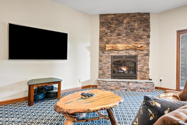 carpeted living room with a stone fireplace