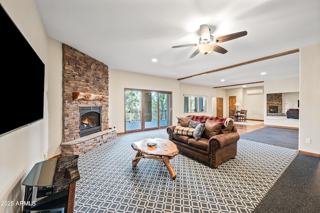 living room with ceiling fan and a fireplace