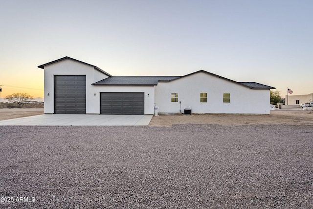 view of front of home with central air condition unit and a garage