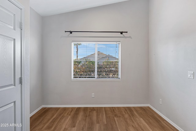 unfurnished room featuring baseboards and wood finished floors