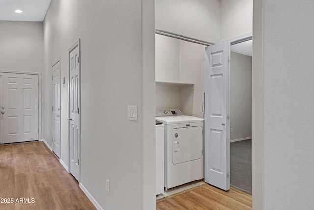 clothes washing area with laundry area, light wood-style floors, baseboards, recessed lighting, and washer and clothes dryer