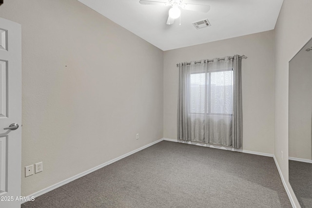 carpeted spare room with visible vents, a ceiling fan, and baseboards