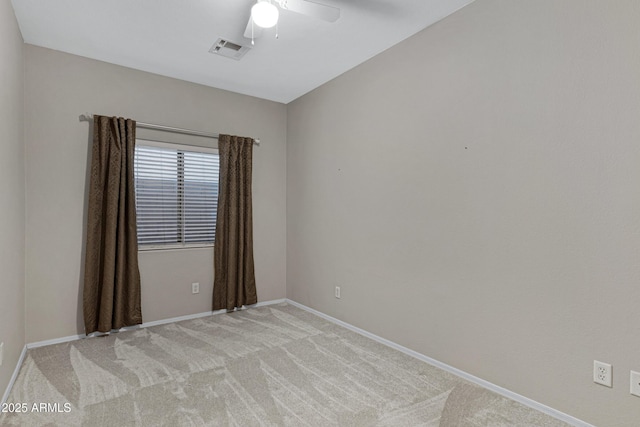 unfurnished room featuring a ceiling fan, light colored carpet, visible vents, and baseboards