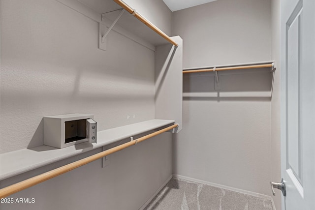 walk in closet featuring carpet flooring