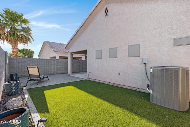 view of yard featuring central AC unit, a fenced backyard, and a patio area
