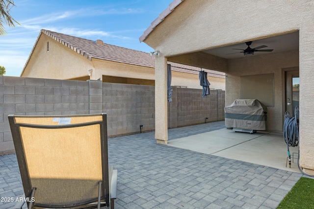 view of patio with fence and a ceiling fan