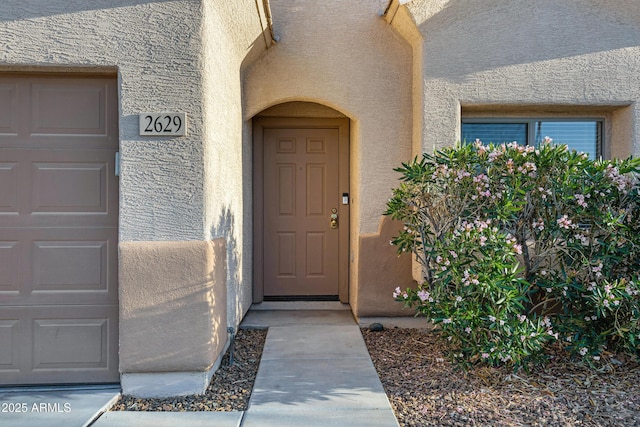 property entrance featuring stucco siding