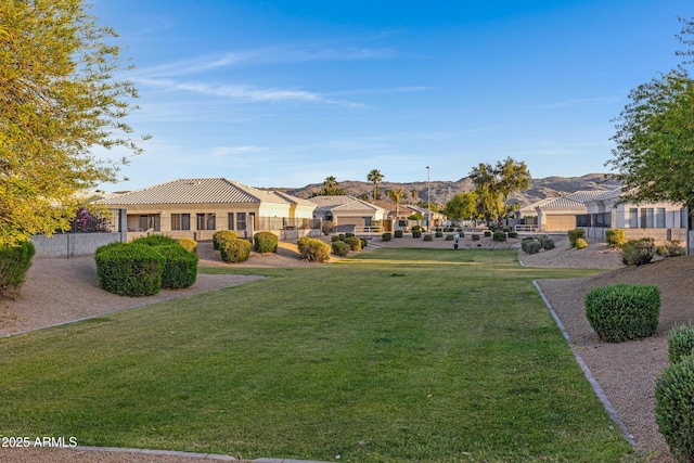 view of yard with fence, a residential view, and a mountain view