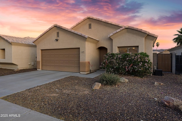 single story home with an attached garage, stucco siding, driveway, and fence