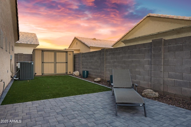 view of patio with an outdoor structure, a fenced backyard, a shed, and cooling unit