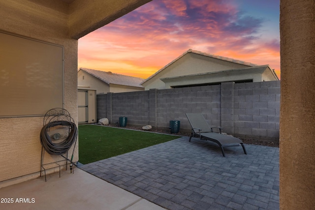 view of patio featuring a storage shed, an outdoor structure, and a fenced backyard