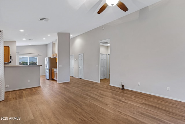 unfurnished living room with visible vents, a ceiling fan, light wood-style flooring, and baseboards