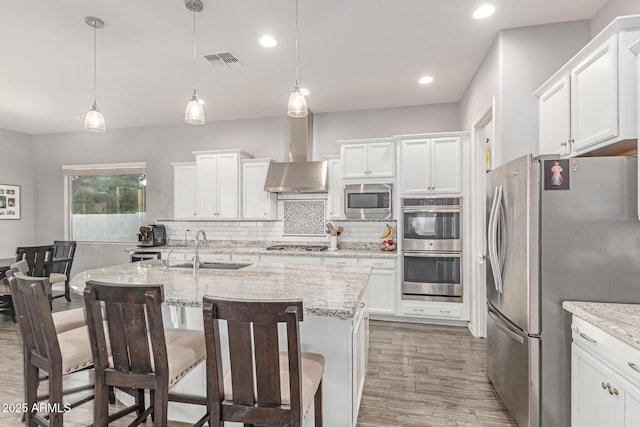3884 S Wilson Dr, Chandler, AZ 85286 - kitchen with appliances with stainless steel finishes, backsplash, light wood-style floors, white cabinets, and a kitchen bar