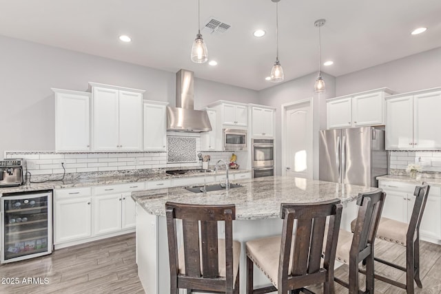 3884 S Wilson Dr, Chandler, AZ 85286 - kitchen featuring wine cooler, appliances with stainless steel finishes, wall chimney exhaust hood, tasteful backsplash, and white cabinets