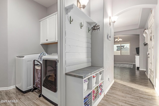 3884 S Wilson Dr, Chandler, AZ 85286 - washroom featuring arched walkways, cabinet space, washing machine and dryer, light wood-style flooring, and a chandelier