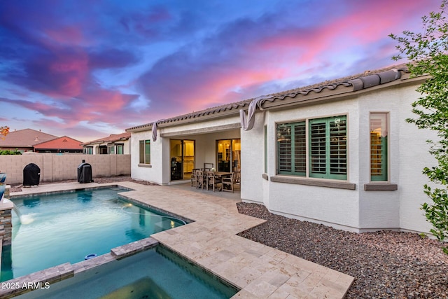 3884 S Wilson Dr, Chandler, AZ 85286 - pool at dusk featuring a patio area, a fenced backyard, and a pool with connected hot tub
