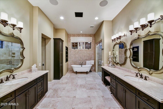 full bathroom with a sink, visible vents, a freestanding bath, and a shower stall