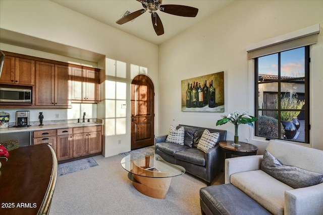 living room featuring visible vents, light carpet, and ceiling fan