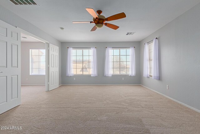 carpeted spare room with ceiling fan