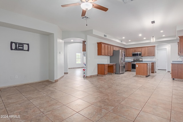 kitchen featuring ceiling fan, hanging light fixtures, light tile patterned floors, a center island, and stainless steel appliances